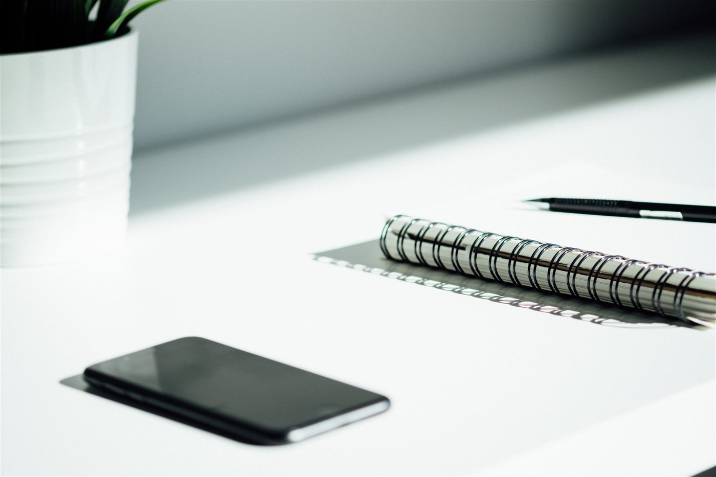 Notebook, phone, and pen arranged for technology planning